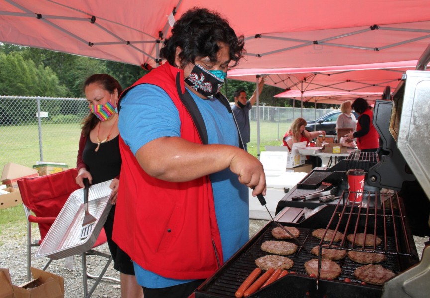 Teechuktl employee Lee Lucas works the barbeque as other staff prepare lunches to be picked up at Dry Creek Park on June 15. (Eric Plummer photo)