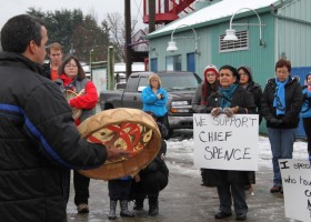 Gail Gus holds a sign in support of Attawapiskat Chief Theresa Spence