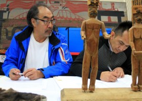 Ha'wilth Jeff Cook looks on as Tyee Derek Peters signs tranfer documents