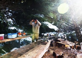 Ryan Sabbas helps Joe Martin carve a canoe for Valeen Jules within Tla-o-qui-aht First Nation traditional territory off the Pacific Rim Highway, on Feb. 16, 2021. 